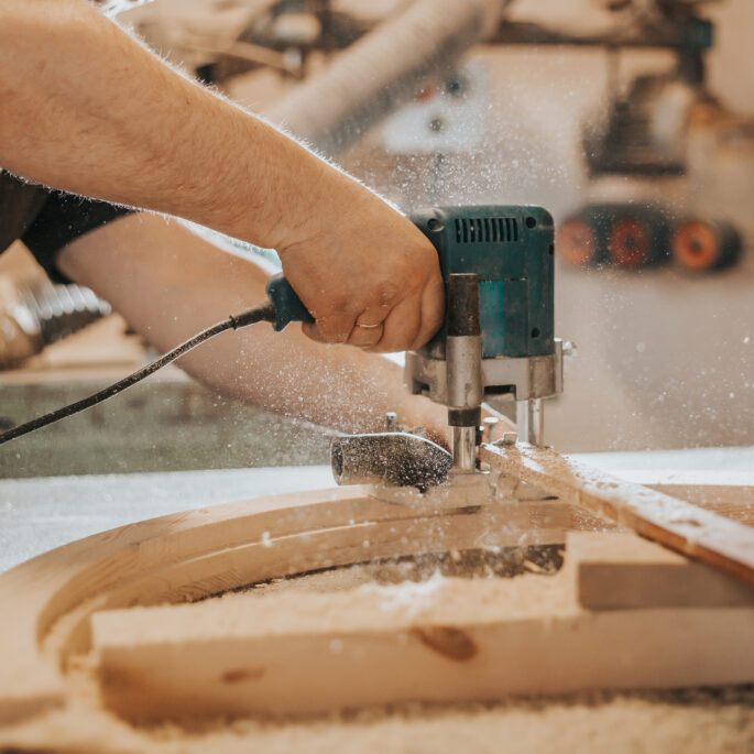 Joinery, woodworking, furniture making, professional carpenter cutting wood in carpentry shop, industrial concept