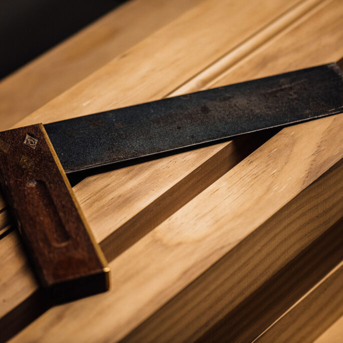 An L-shaped woodworking tool sits atop a workbench in the Tucker Joinery workshop, Andover.