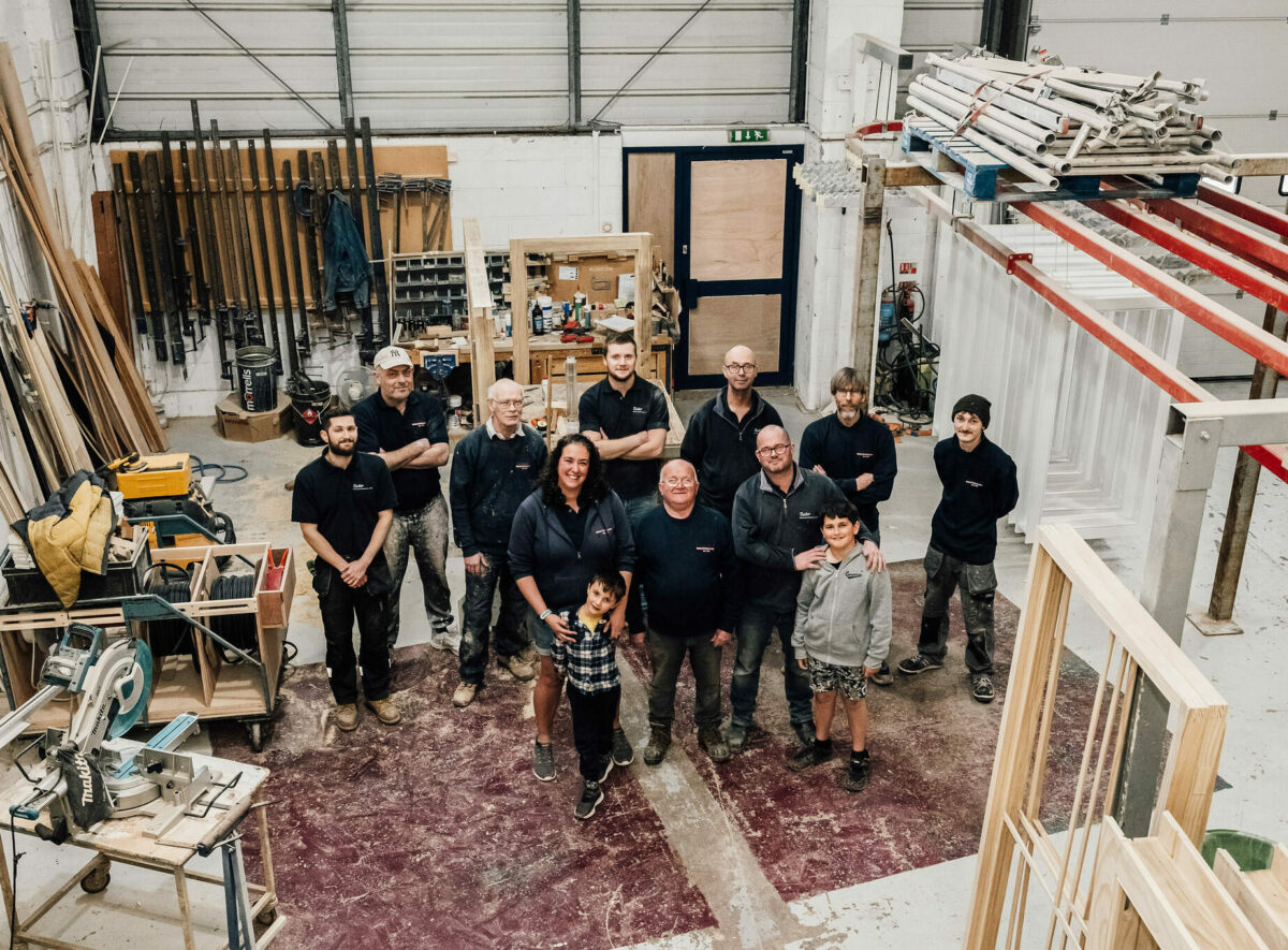 A top-down photo of the Tucker Joinery Team stood together in the workshop.