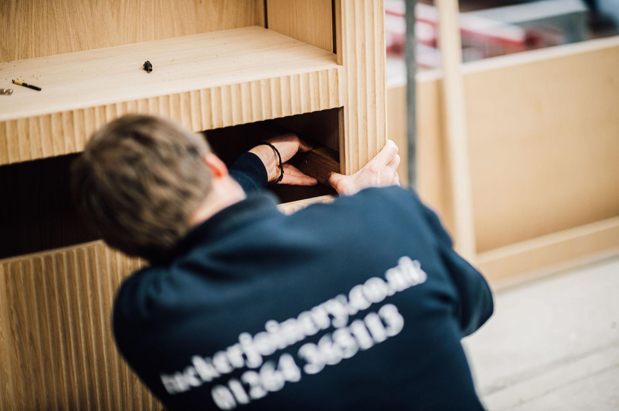 A team member at tucker Joinery put the finishing touches to a handmade cabinet at the Tucker Joinery workshop, Andover.