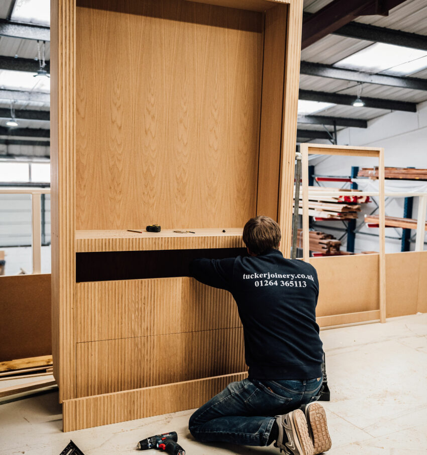 A member of the Tucker Joinery team builds a bespoke timber cabinet in the workshop, based in Andover.