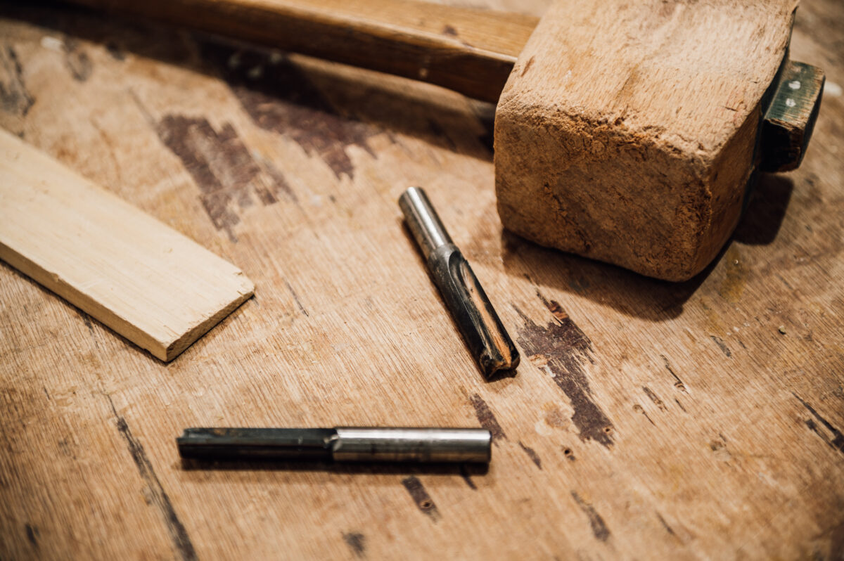 A mallet and two small wood routers sit atop a workbench in the Tucker Joinery workshop.