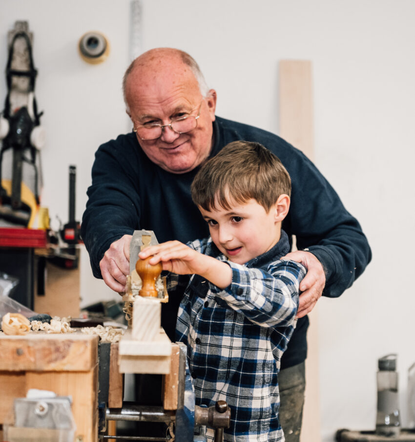 Little Ollie Tucker helps his grandfather Dave Tucker in the Tucker Joinery workshop.