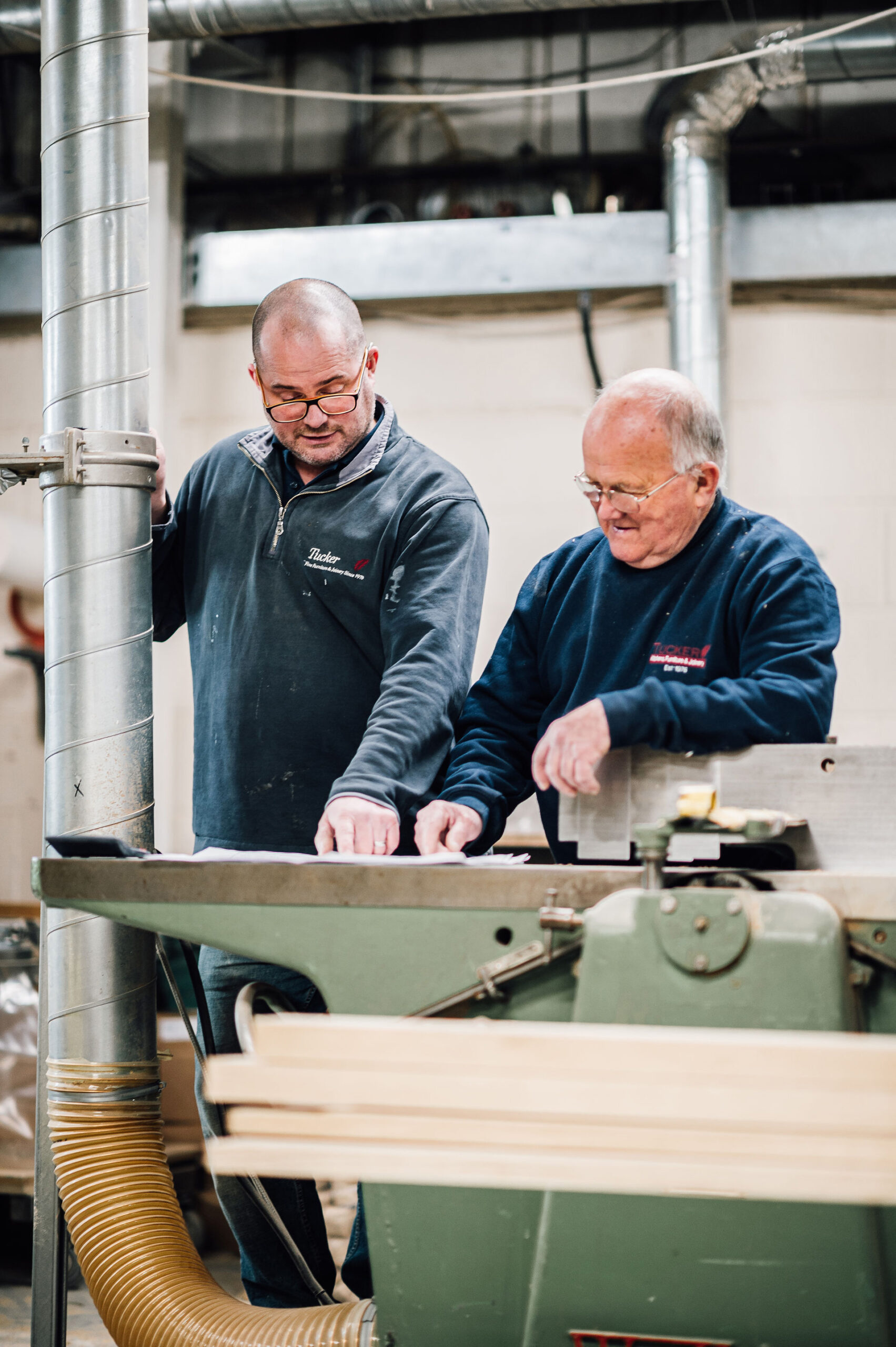 Lee and Dave Tucker, working together looking at a timber furniture plan in the Tucker Joinery workshop.