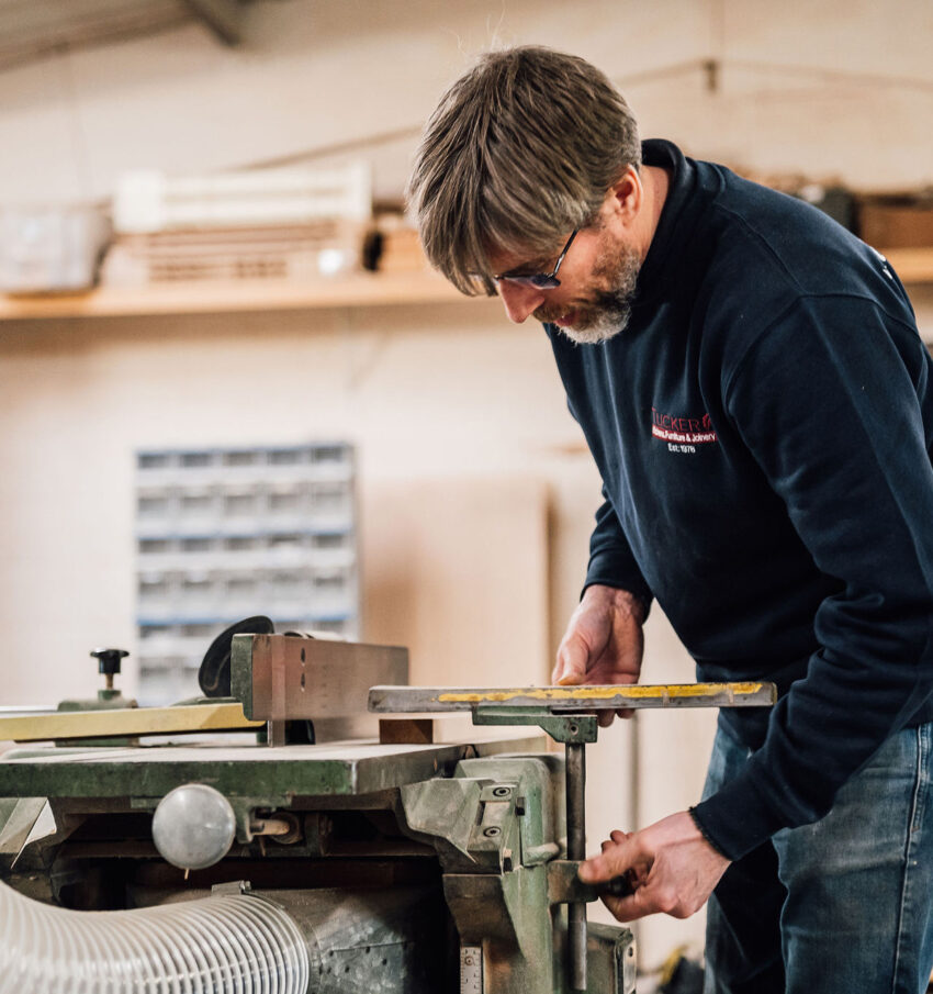 A member of the Tucker Joinery woodworking team operates a metal jaw vice in the workshop, ready for a timber insert. Workshop based in Andover.