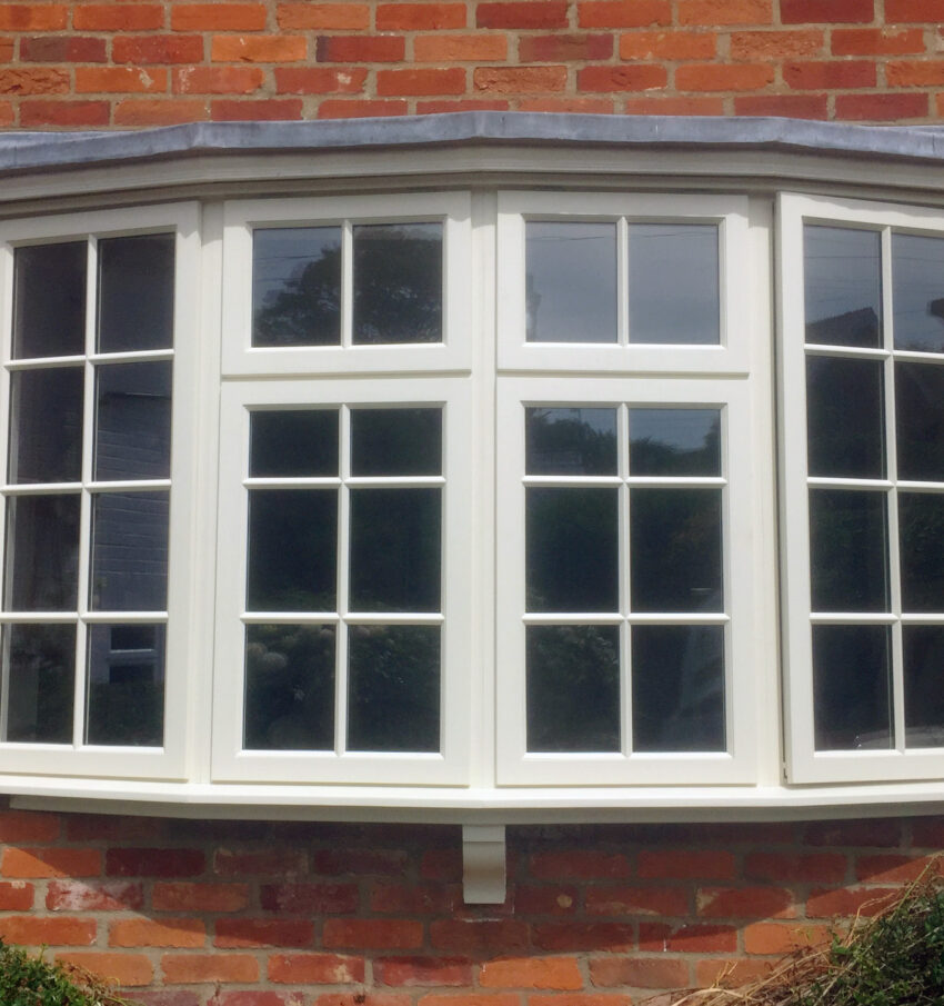 Bespoke mounted window design by Tucker Joinery. Finished in white paint the window is mounted in a brick house.